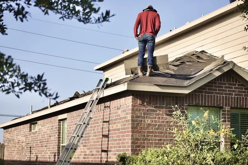 Professional roofer working on a residential roof in West Mansfield